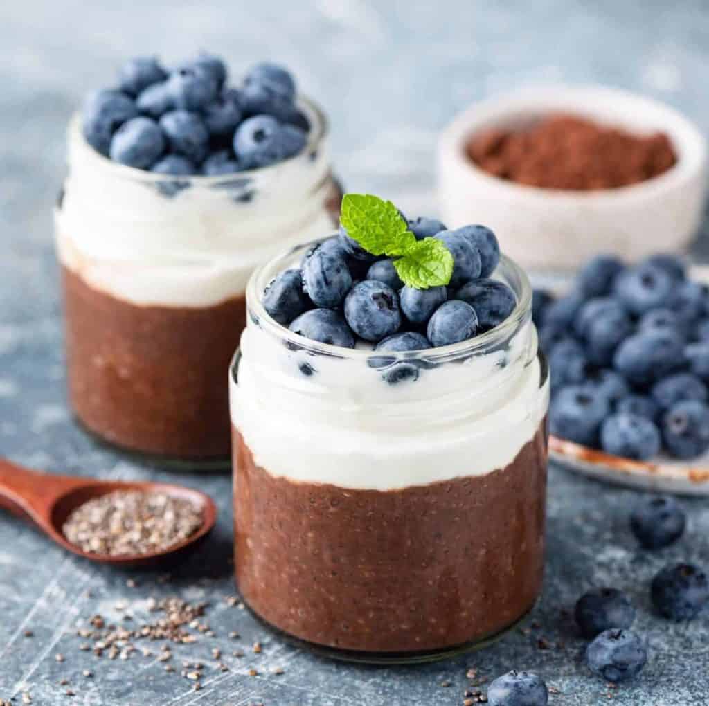 Mousse aux myrtilles dans des pots avec myrtilles fraîches et menthe.