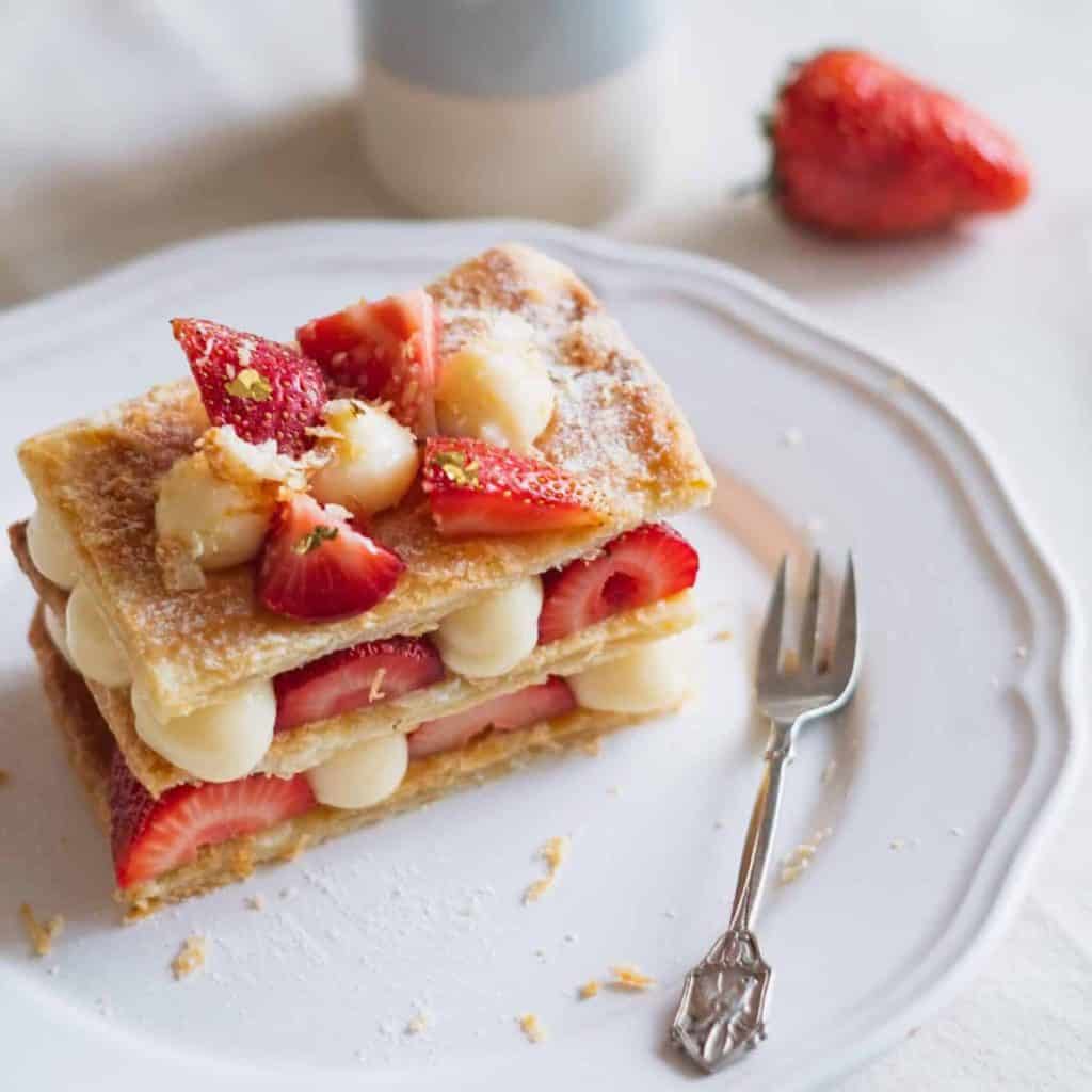 Gâteau aux fraises, crème et biscuits, décoré de fraises fraîches.