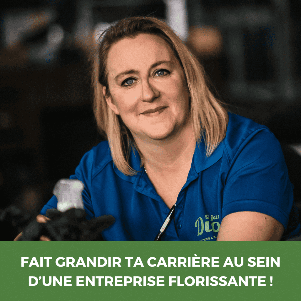Femme en uniforme de jardinage souriante dans un environnement vert.